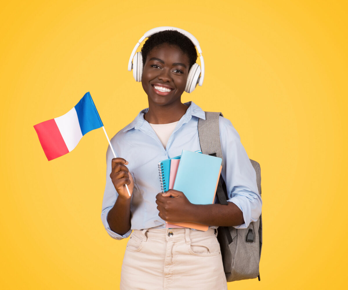 The young black student proudly holding a French flag symbolizes international awareness among zoomers Isolated, vibrant yellow background